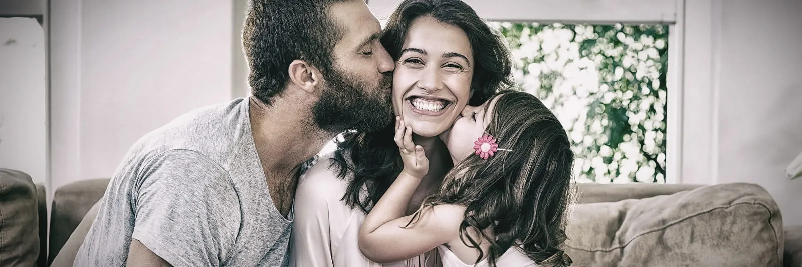 Family hugging and smiling on a sofa