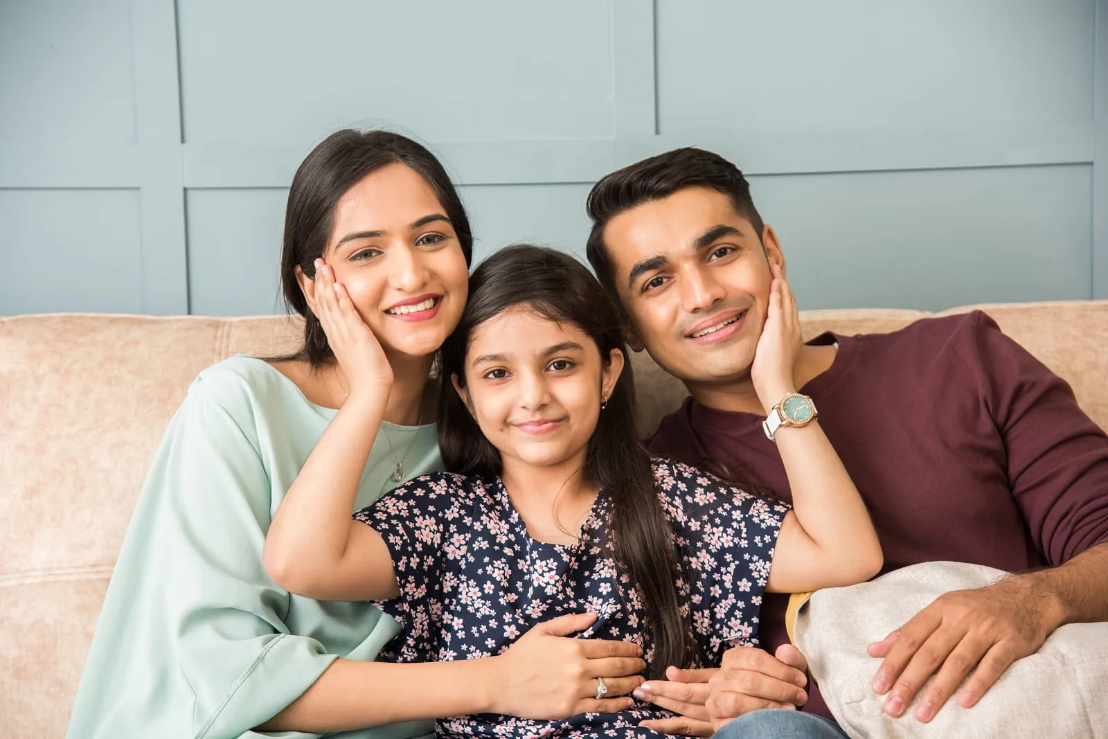 Indian family smiling together on a sofa