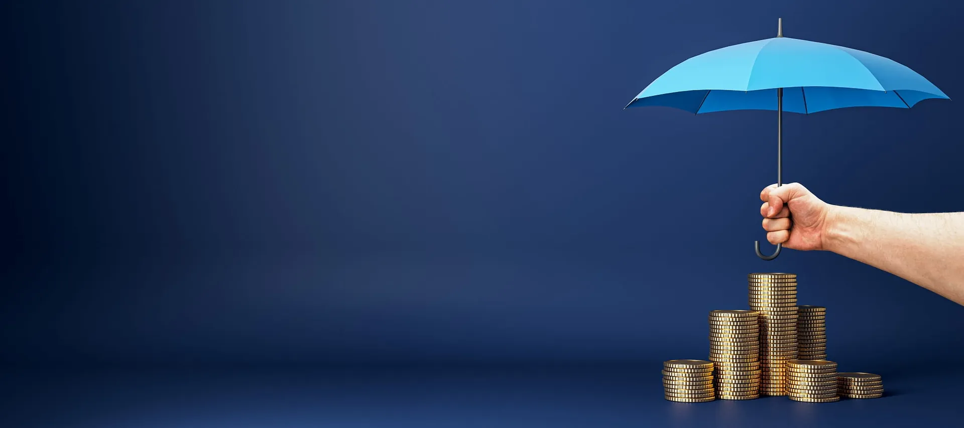 Hand holding an umbrella over stacks of coins on a dark blue background