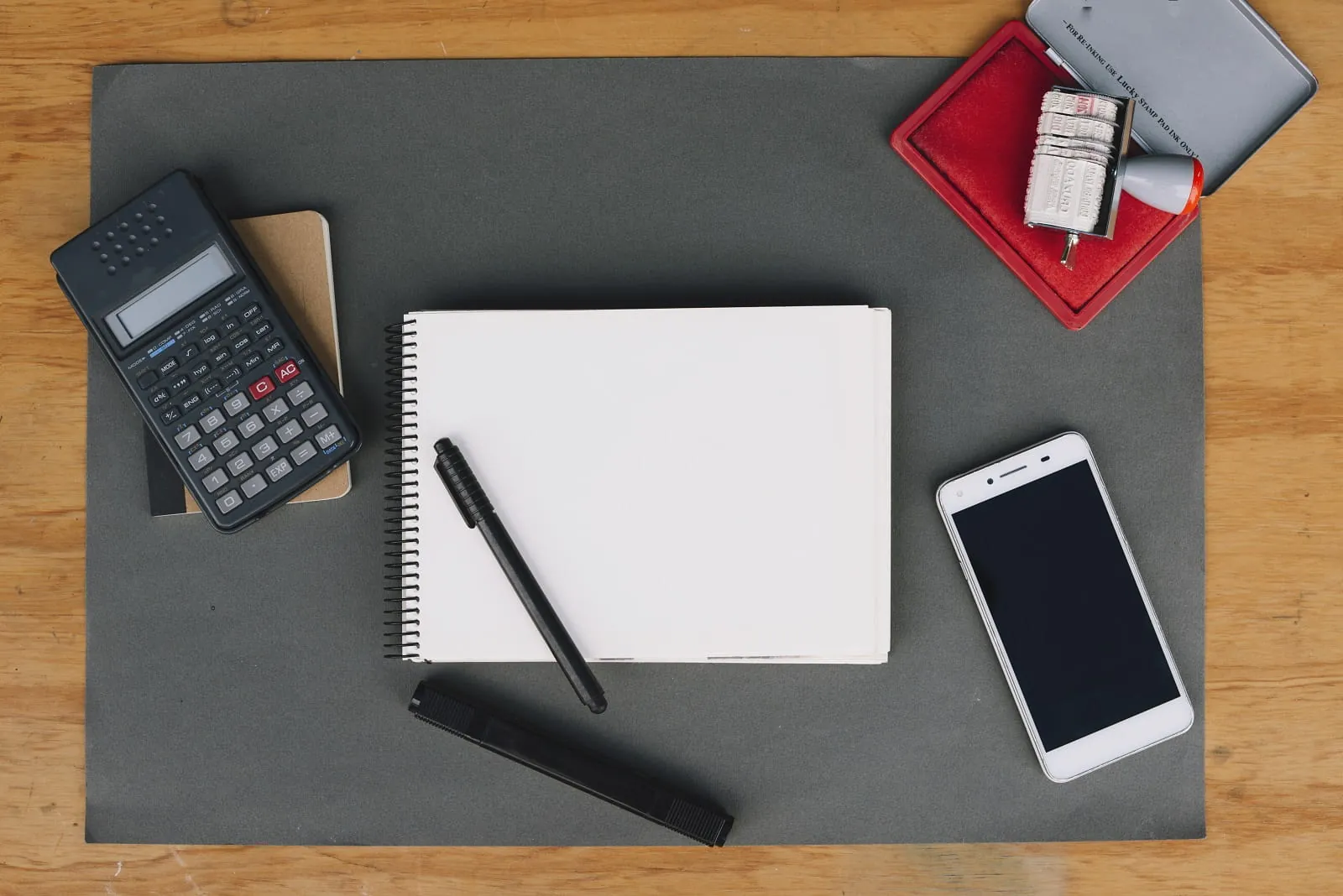 Calculator, notebook, pen and phone on a desk