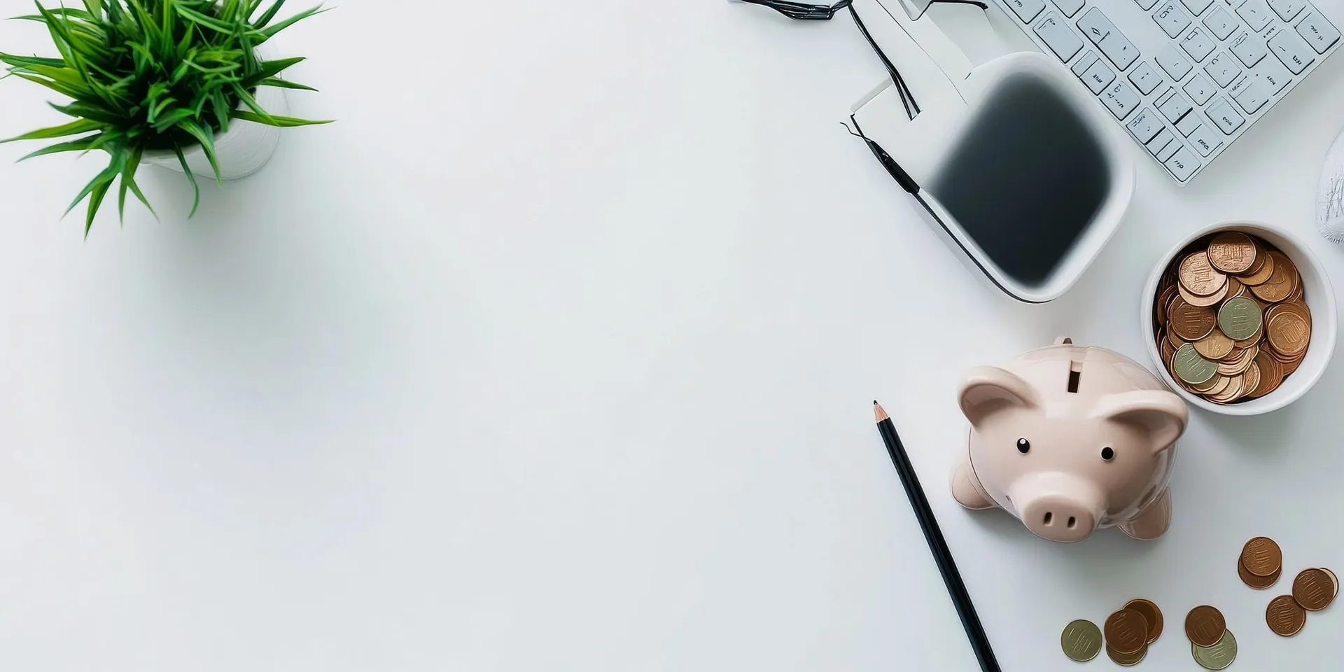 Desk with a keyboard, piggy bank, coins and a plant