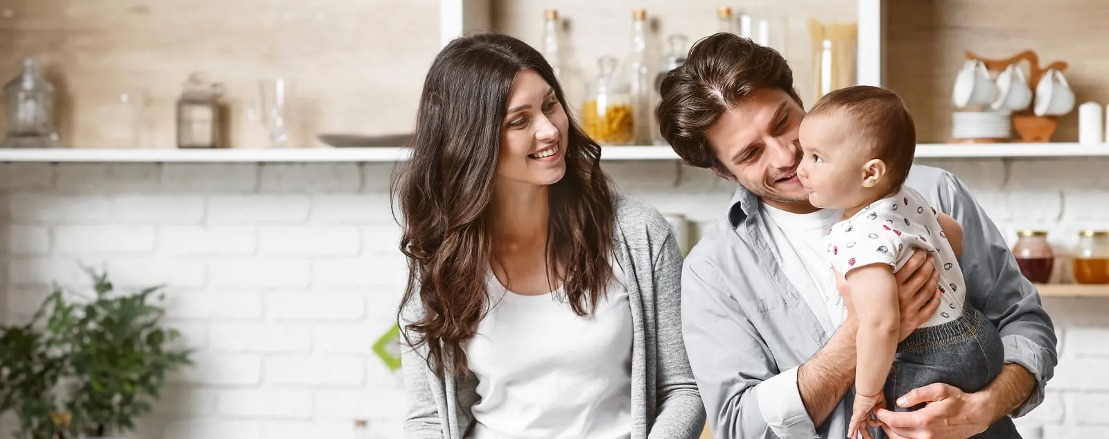 Family with a baby smiling together in a kitchen
