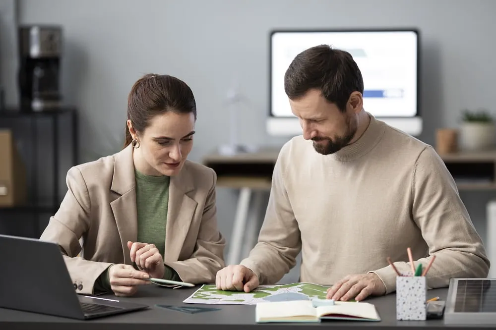Couple reviewing papers together at a desk with a laptop