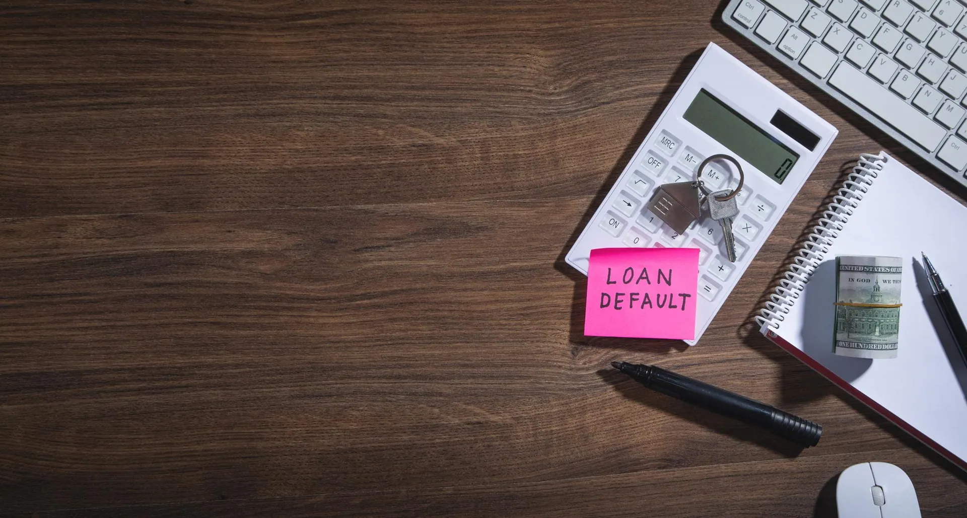 Calculator, keys and loan notes on a wooden desk
