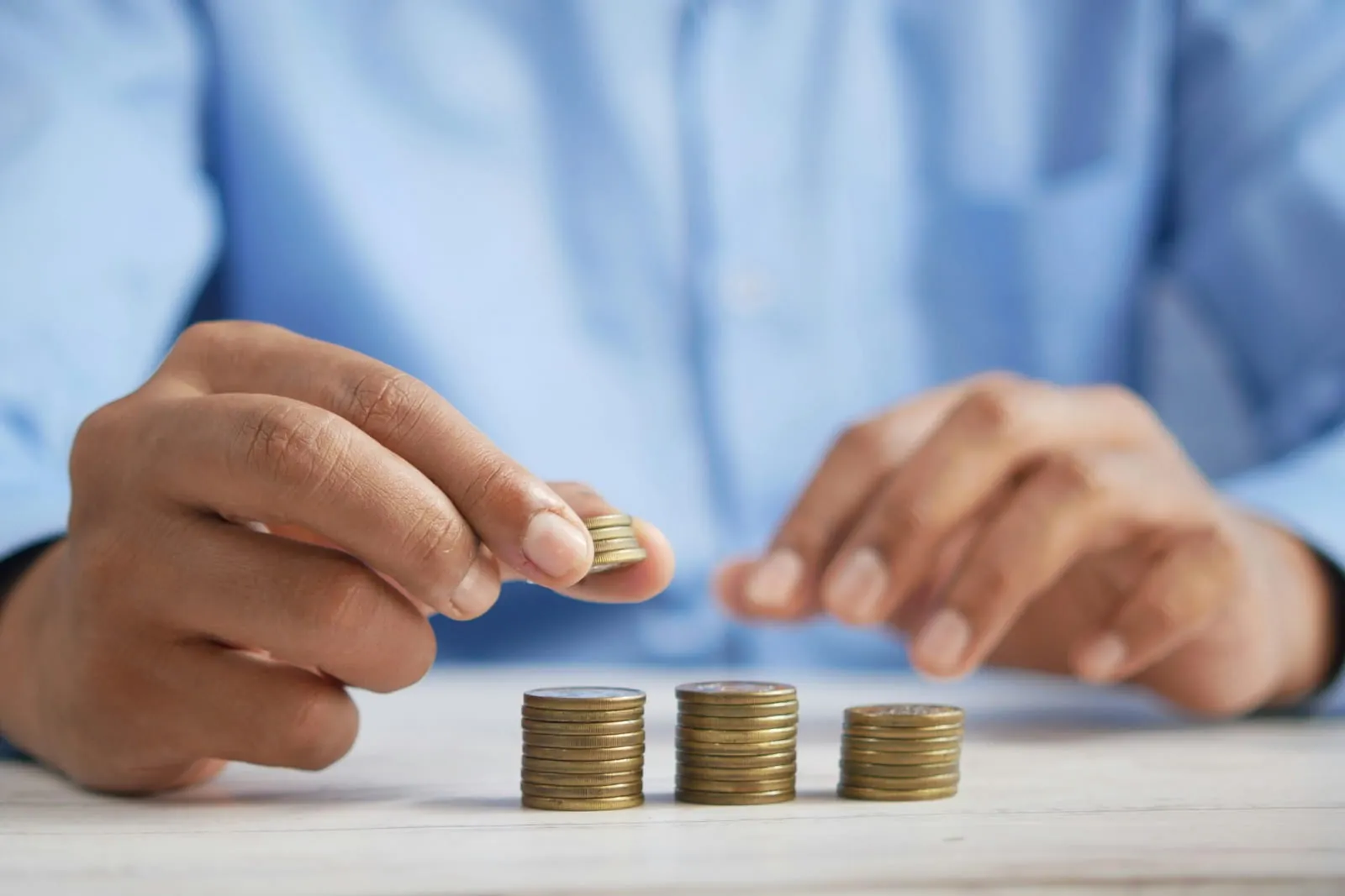 Hand stacking coins on a table